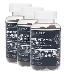Three bottles of Particle Hair Vitamin Gummies standing in a row.