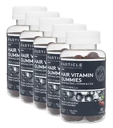 Five transparent bottles of Particle Hair Vitamin Gummies with white caps standing in a row.