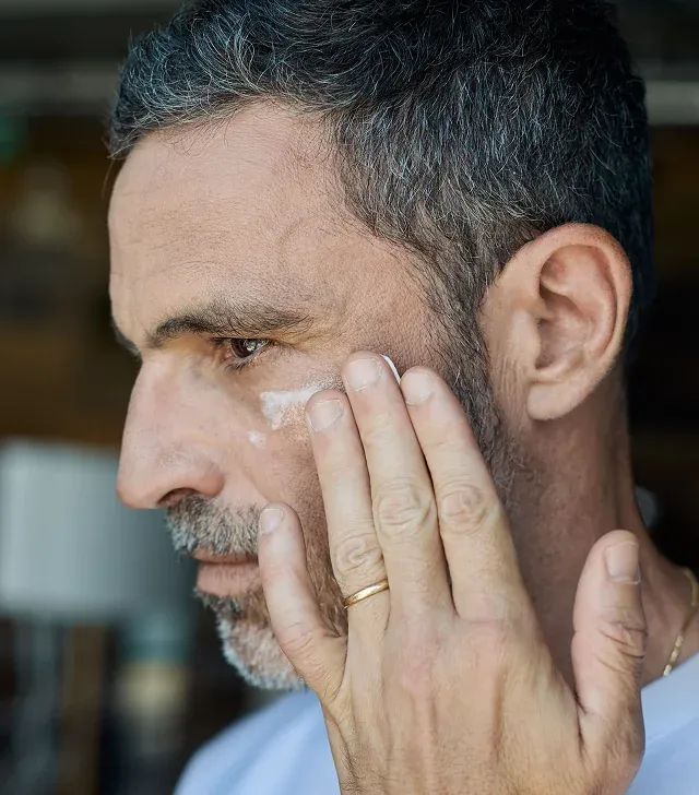 Man applying face cream to his face.